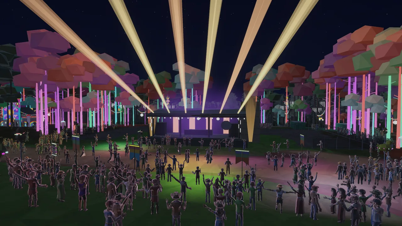 Dancers in front of a small stage in a forest of uplit, colourful trees with light beams